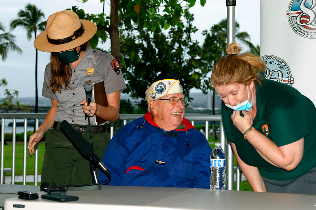 Pearl Harbor survivor Herb Elfring, center, speaks with National Park Service workers in Pearl Harbor, Hawaii on Sunday, Dec. 5, 2021. A few dozen survivors of Pearl Harbor are expected to gather Tuesday at the site of the Japanese bombing 80 years ago to remember those killed in the attack that launched the U.S. into World War II. (AP Photo/Audrey McAvoy)