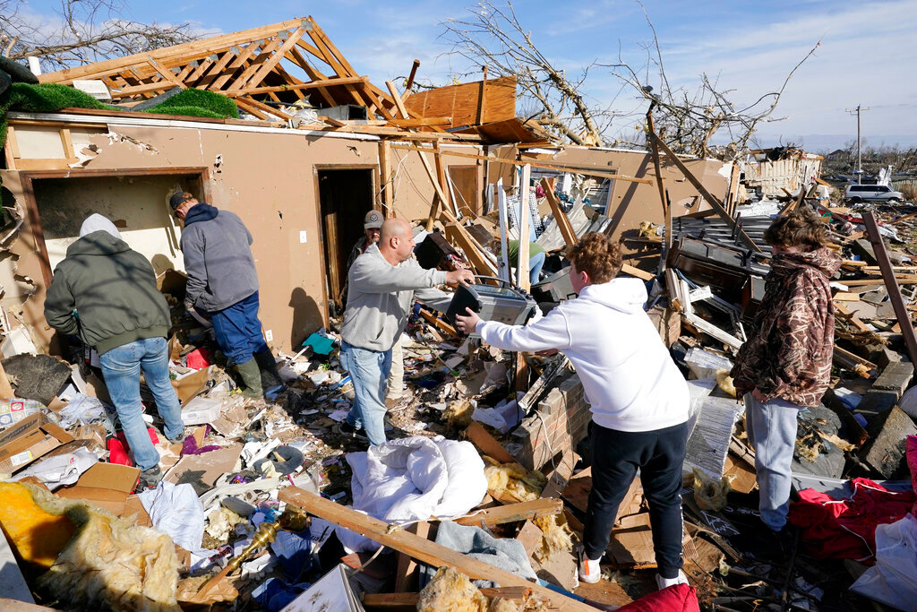 People help retrieve items from a destroyed home Saturday, Dec. 11, 2021, in Mayfield, Ky. Tornadoes and severe weather caused catastrophic damage across several states Friday, killing multiple people overnight. (AP Photo/Mark Humphrey)