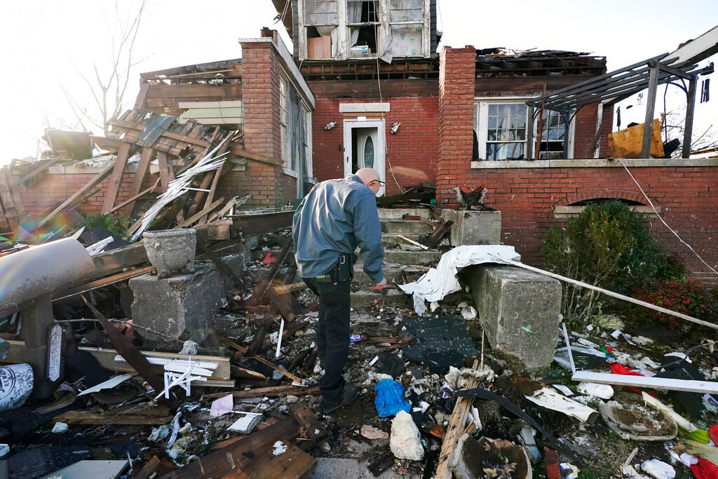 Timothy McDill walks near his tornado-damaged home in Mayfield, Ky., on Saturday, Dec. 11, 2021. Tornadoes and severe weather caused catastrophic damage across several states late Friday, killing multiple people overnight. (AP Photo/Mark Humphrey)