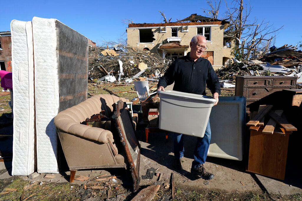 Sam Willett helps to salvage items from a friends' home Sunday, Dec. 12, 2021, in Mayfield, Ky. Tornadoes and severe weather caused catastrophic damage across several states Friday, killing multiple people overnight. (AP Photo/Mark Humphrey)