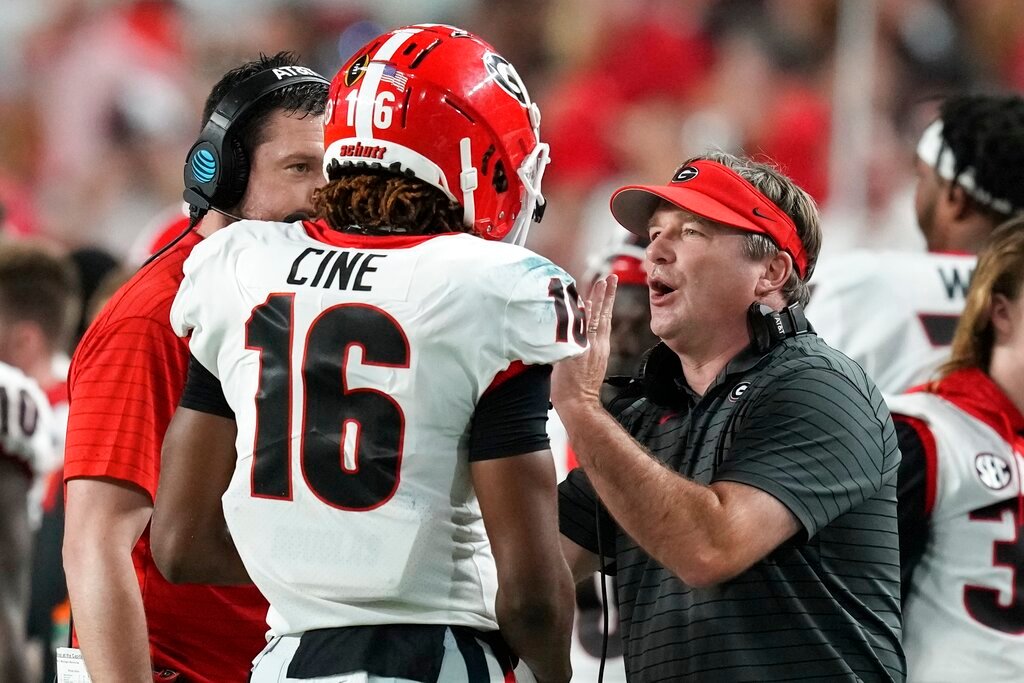 Georgia head coach Kirby Smart talks with defensive back Lewis Cine during the first half of the Orange Bowl NCAA College Football Playoff semifinal game against Michigan, Friday, Dec. 31, 2021, in Miami Gardens, Fla. (AP Photo/Rebecca Blackwell)