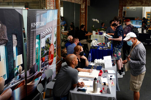 FILE - Prospective employers and job seekers interact during during a job fair on Sept. 22, 2021, in the West Hollywood section of Los Angeles. Hiring in California slowed significantly in November 2021 even as the state's unemployment rate dipped below 7% for the first time since March 2020, at the start of the pandemic, according to data made public Friday, Dec. 17, 2021. (AP Photo/Marcio Jose Sanchez, File)