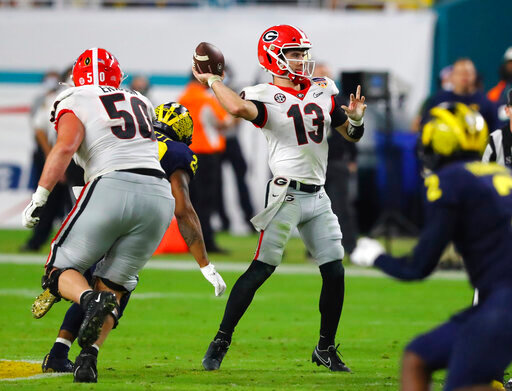 Georgia Bulldogs quarterback Stetson Bennett (13) throws a 39 yard touchdown pass to Georgia Bulldogs running back James Cook (4) in the 4th quarter of the 2021 College Football Playoff Semifinal between the Georgia Bulldogs and the Michigan Wolverines at the Orange Bowl at Hard Rock Stadium in Miami Gardens. (Curtis Compton/Atlanta Journal-Constitution via AP)