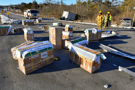 Crates holding live monkeys are scattered across the westbound lanes of state Route 54 at the junction with Interstate 80 near Danville, Pa., Friday, Jan. 21, 2022, after a pickup pulling a trailer carrying the monkeys was hit by a dump truck. They were transporting 100 monkeys and several were on the loose at the time of the photo. (Jimmy May/Bloomsburg Press Enterprise via AP)