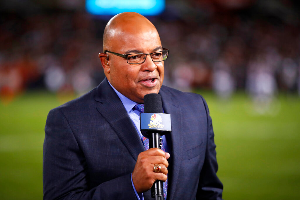 FILE - In this Sept. 5, 2019, file photo, NBC sportscaster Mike Tirico works the sidelines during an NFL football game between the Green Bay Packers and the Chicago Bears in Chicago. Tirico is one of many announcers who has had to trade the press box for a home office. (AP Photo/Jeff Haynes, File)