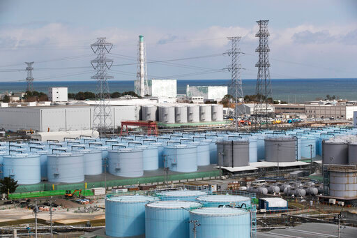 In this Saturday, Feb. 27, 2021, file photo, Nuclear reactors of No. 5, center left, and 6 look over tanks storing water that was treated but still radioactive, at the Fukushima Daiichi nuclear power plant in Okuma town, Fukushima prefecture, northeastern Japan. The industry and foreign ministries announced Monday, Feb. 7, 2022, that a team of experts from the International Atomic Energy Agency will visit Japan's wrecked Fukushima nuclear power plant next week to review plans to begin releasing millions of gallons of treated radioactive water into the sea, a mission the government hopes will assure people of its safety. (AP Photo/Hiro Komae, file)