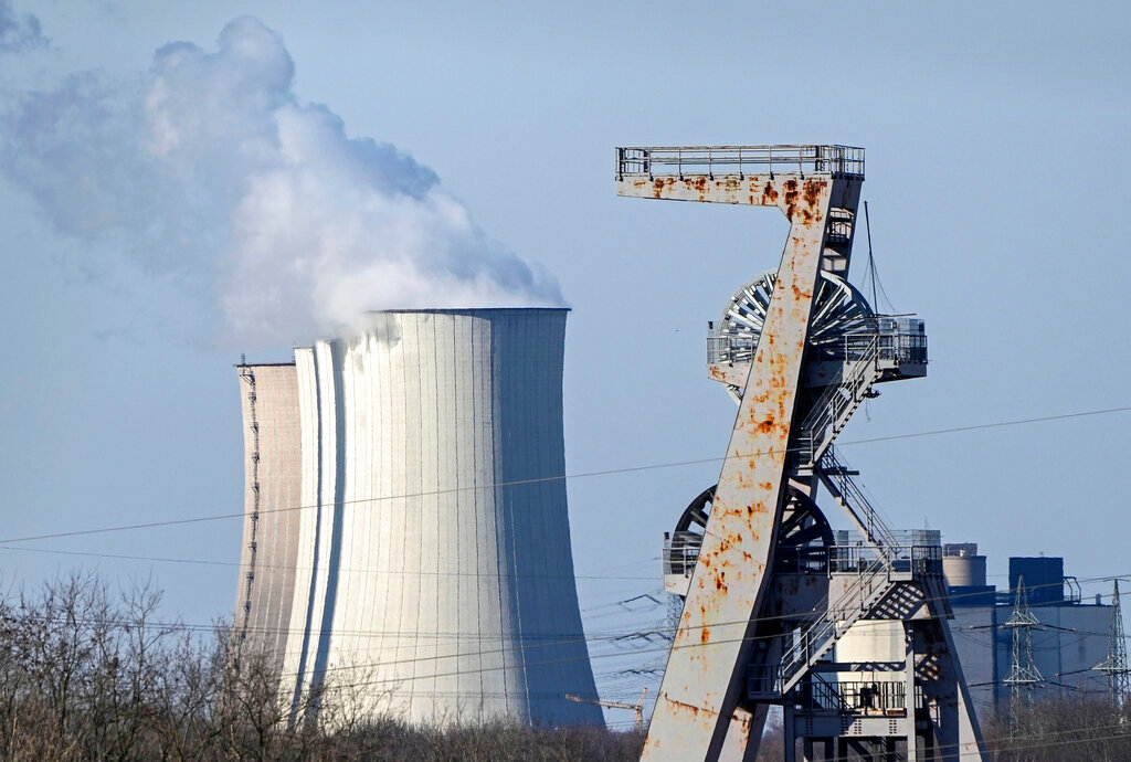 A winding tower of a closed coal mine rusts in front of a coal-fired power station Gelsenkirchen, Germany, Tuesday, March 8, 2022. Compared to the U.S., the 27-member European Union faces much stronger direct economic consequences than does the U.S. from Russia’s invasion of Ukraine and the resulting sanctions _ and that’s true above all when it comes to the oil and gas that fuels vehicles and keeps the heat and the lights on. (AP Photo/Martin Meissner, File)