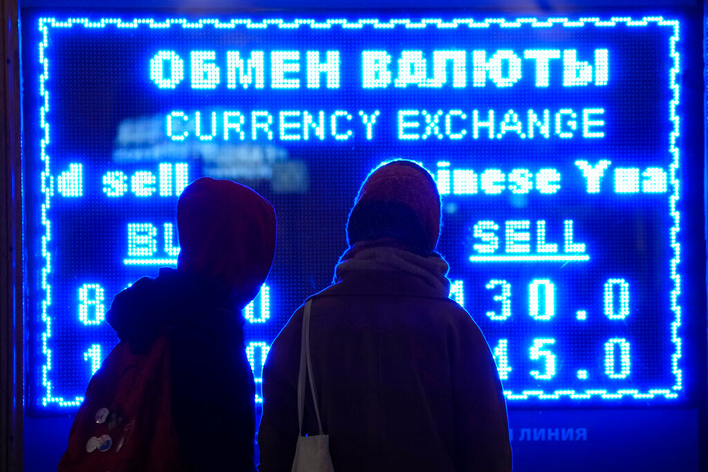Women look at a screen displaying exchange rate at a currency exchange office in St. Petersburg, Russia, Tuesday, March 1, 2022.  (AP Photo/Dmitri Lovetsky, File)