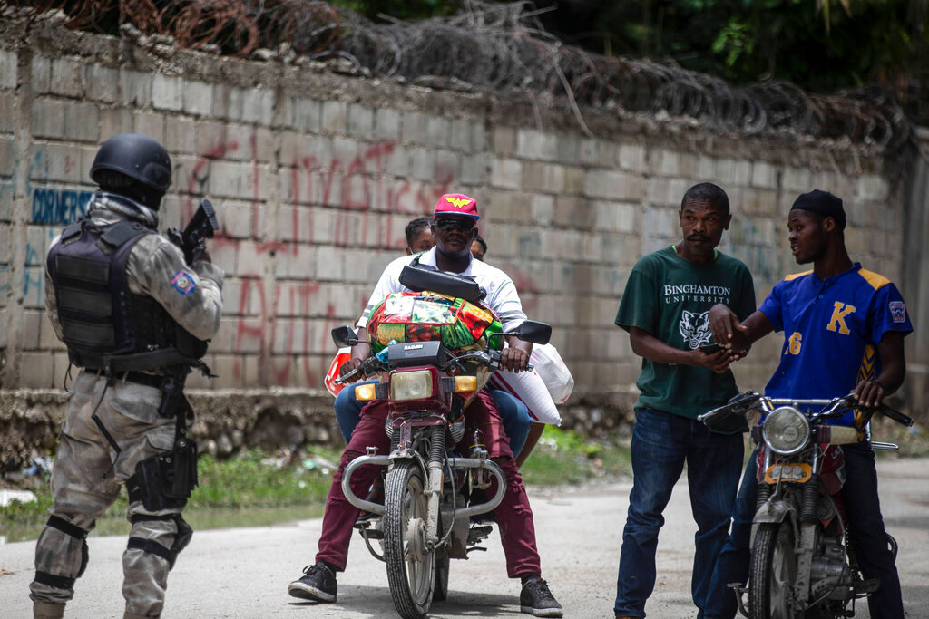A police officer patrols a street during an anti-gang operation in Croix-des-Missions north of Port-au-Prince, Haiti, Thursday, April 28, 2022. (AP Photo/Odelyn Joseph)