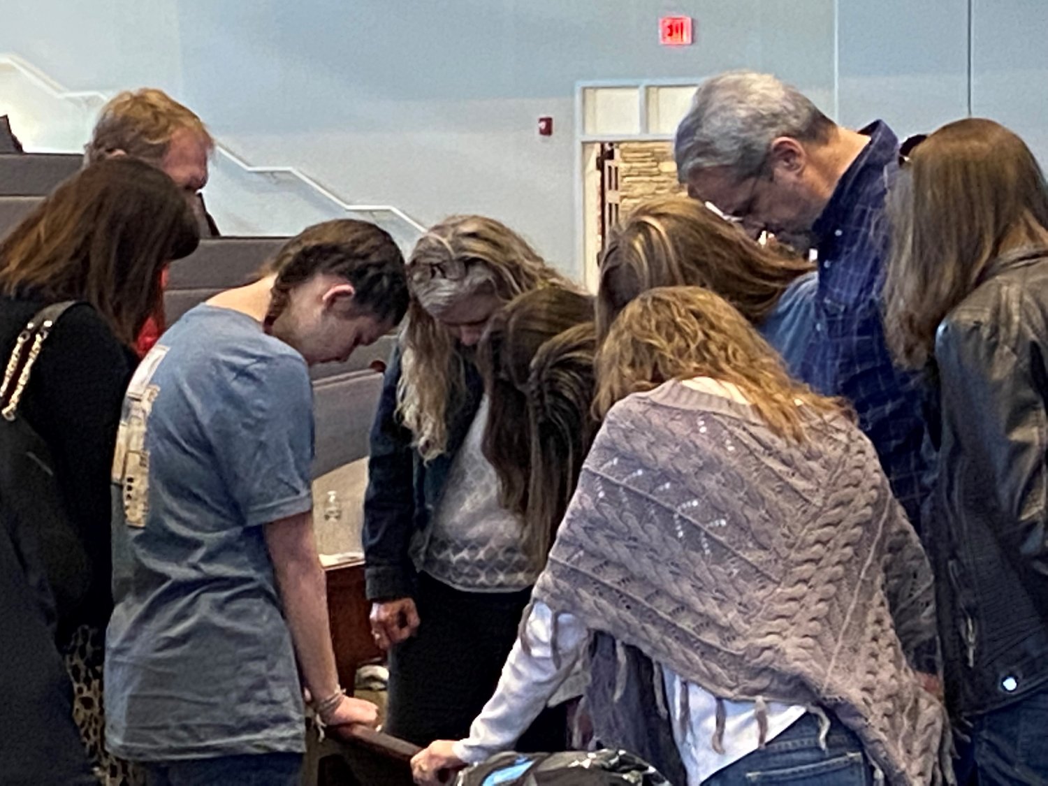 Student missionaries Sarah-Elizabeth Cheek of Shorter University, McKenzie Cloud, UGA and Elise King, Georgia Tech, and their families pray Saturday, April 9, during a commissioning service at Glen Haven Baptist Church in McDonough, Ga. (Photo/Clarissa Morrison, Georgia Baptist Mission Board)