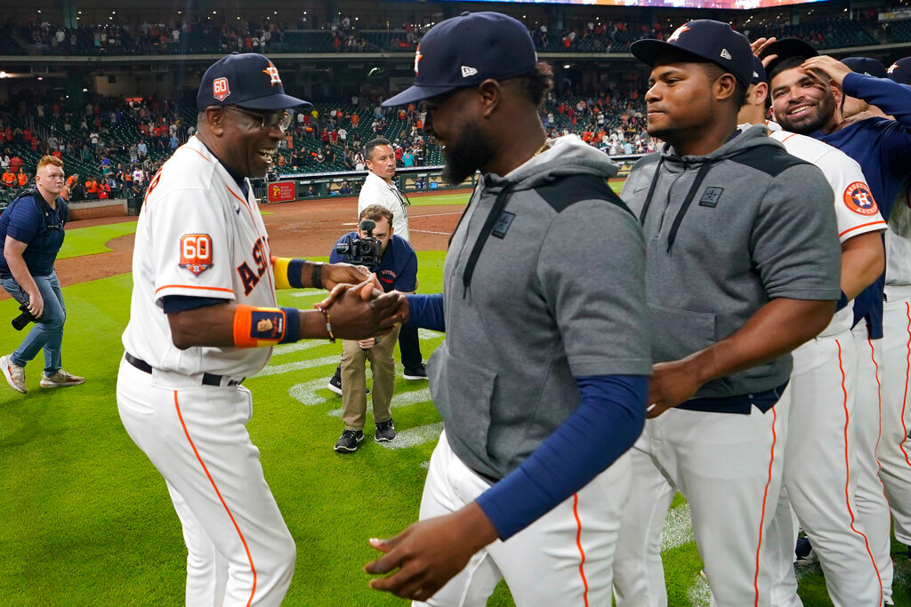 Houston Astros manager Dusty Baker Jr., left, celebrates with players after a baseball game against the Seattle Mariners, Tuesday, May 3, 2022, in Houston. Baker won his 2,000th game Tuesda, becoming the 12th skipper in major league history to reach the milestone and the first Black man to do it. (AP Photo/David J. Phillip)