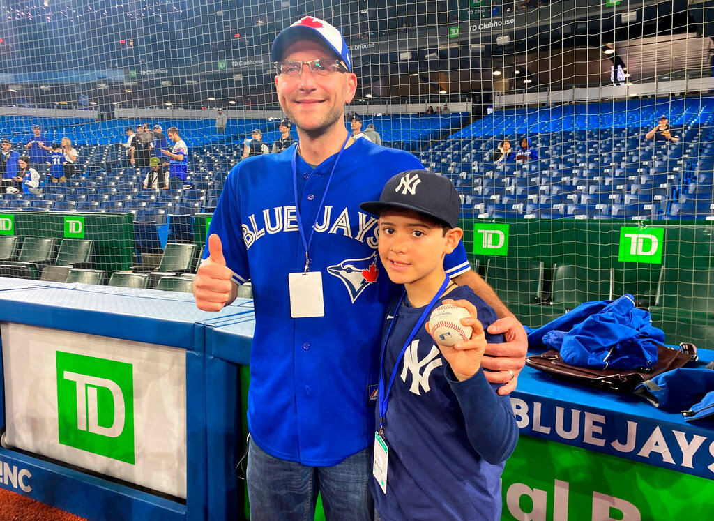 Nine-year-old Derek Rodriguez poses for a photo with Mike Lanzillotta, the Blue Jays fan who caught Aaron Judge's home run ball a night earlier and handed it to the youngster, before the start of a baseball game between the Yankees and the Toronto Blue Jays in Toronto, Wednesday, May 4, 2022. The young New York Yankees fan's dreams came true when he was handed a home-run ball hit by Aaron Judge. A clip of the interaction quickly went viral. Rodriguez and Lanzillotta were on hand to watch batting practice Wednesday afternoon and later met Judge in the Yankees dugout. (Photo/Gregory Strong, Canadian Press via AP)