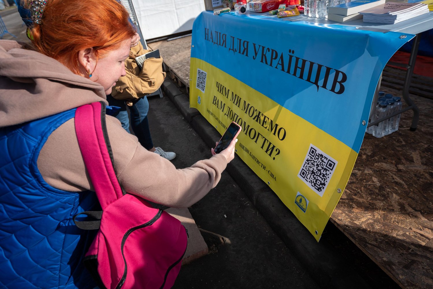 Oksana scans the Hope for Ukraine QR code at the station established by Romanian Baptists and now manned by Southern Baptist Disaster Relief Team station on the border of Ukraine and Romania. The website provides the opportunities to talk directly with Ukrainian and Russian-speaking Christians.  (Photo/IMB)