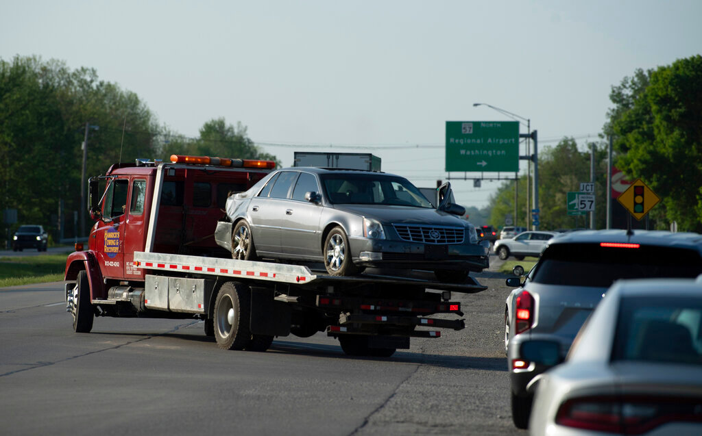 A tow truck hauls the Cadillac sedan that fugitives Casey White and Vicky White, no relation, were driving when law enforcement officials forced them into a ditch in Evansville, Ind., after a short chase Monday, May 9, 2022. The two have been on the run since Vicky White, a detention officer, helped inmate Casey White escape the Lauderdale County Detention Center on April 28. (Photo/Denny Simmons, Evansville Courier & Press via AP)