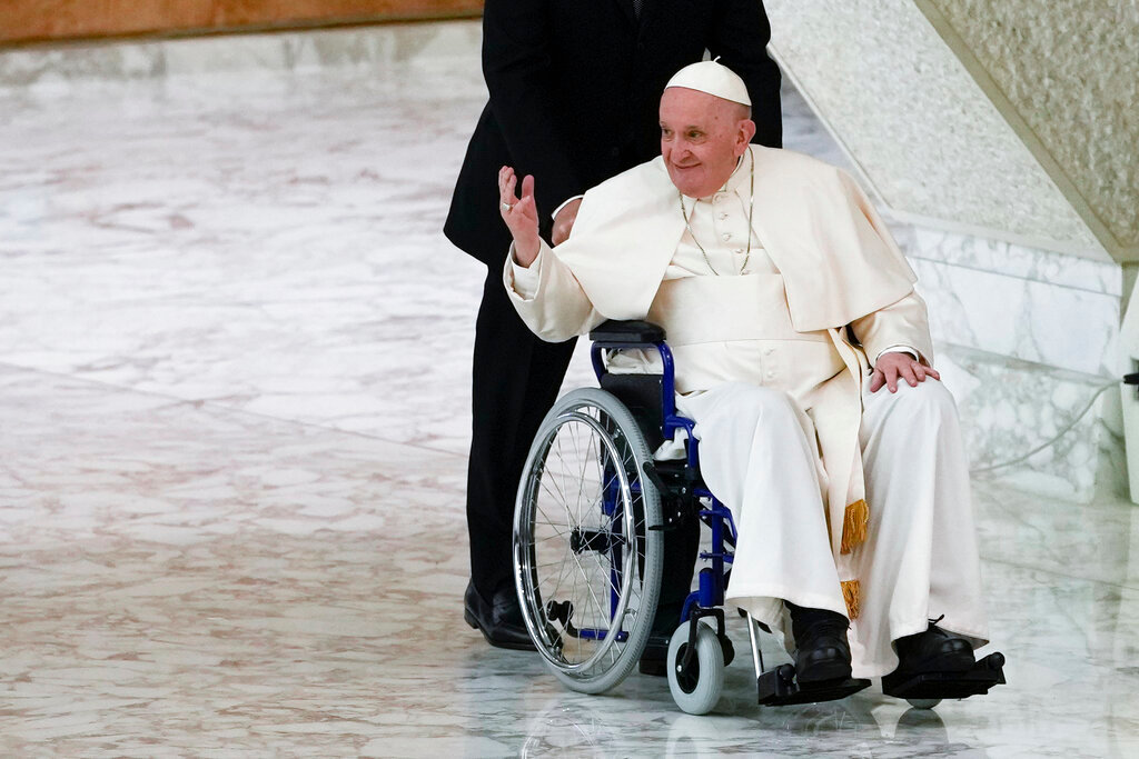 Pope Francis arrives in a wheelchair to attend an audience at The Vatican, May 5, 2022. The pope is known to be suffering acute knee pain that has greatly curtailed his mobility in recent months. (AP Photo/Alessandra Tarantino, File)