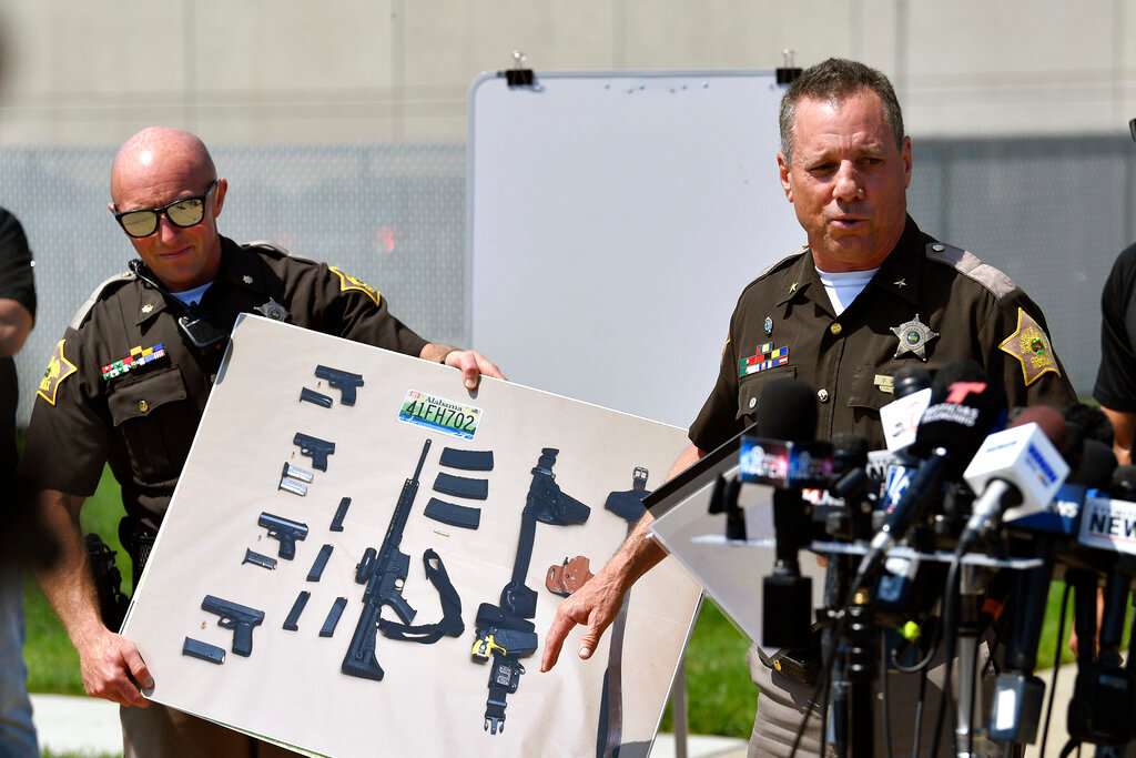 Vanderburgh County Sheriff Dave Wedding shows a photograph of the weapons that were found in the possession of fugitives Casey White and Vicky White following their capture during a press conference in Evansville, Ind., Tuesday, May 10, 2022. (AP Photo/Timothy D. Easley)