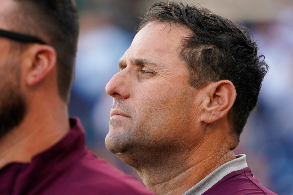 Mississippi State coach Chris Lemonis listens to the singing of the national anthem prior to the start of the Governor's Cup NCAA college baseball game against Mississippi, April 26, 2022, in Pearl, Miss. Mississippi State has lost five straight games and is in danger of becoming the fifth national champion since 2007 to not make it back to the next NCAA Tournament. (AP Photo/Rogelio V. Solis)