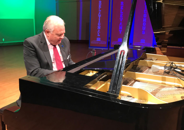 Rick Brewer, president of Louisiana Christian University, plays piano on stage at the school's Pineville campus in this 2021 photo. In rural America, churches are having trouble finding pianists. (Photo/Baptist Press)