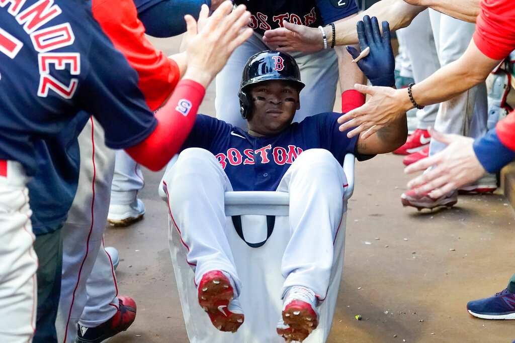Boston Red Sox' Rafael Devers (11) is pushed through the dugout in a laundry cart as he celebrates after hitting a grand slam in the second inning against the Atlanta Braves Tuesday, May 10, 2022, in Atlanta. Devers' first career grand slam led the Sox to a 9-4 win over the Atlanta Braves that ended a five-game skid. (AP Photo/John Bazemore)