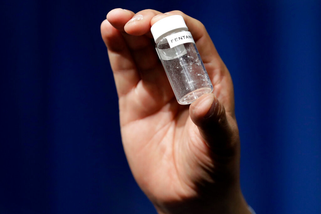 A reporter holds up an example of the amount of fentanyl that can be deadly after a news conference at DEA Headquarters in Arlington, Va. The Georgia Department of Public Health discussed increasing fentanyl overdose deaths, COVID rates, and a mysterious hepatitis outbreak among children at its monthly meeting Tuesday. {AP Photo/Jacquelyn Martin, File)