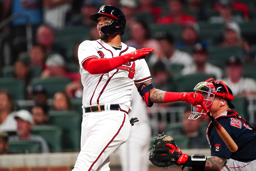 Atlanta Braves' Orlando Arcia (11) follows through on a two-run walkoff home run as Boston Red Sox catcher Christian Vazquez (7) looks on in the ninth inning Wednesday, May 11, 2022, in Atlanta. (AP Photo/John Bazemore)