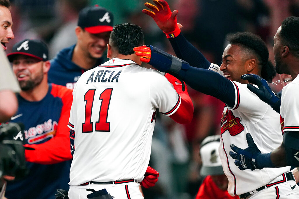 Atlanta Braves' Orlando Arcia is mobbed by teammates after hitting a two-run walkoff home run in the ninth inning against the Boston Red Sox, Wednesday, May 11, 2022, in Atlanta. (AP Photo/John Bazemore)