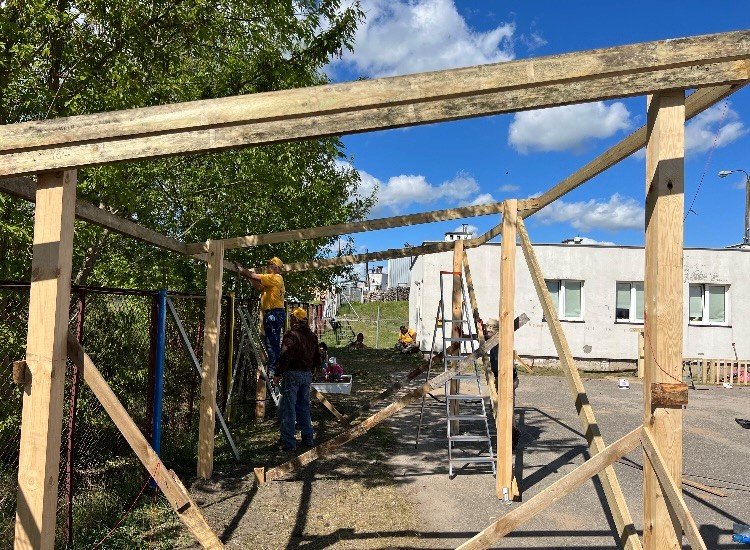 Volunteers from Georgia build a shelter in a Polish camp for Ukrainian refugees.