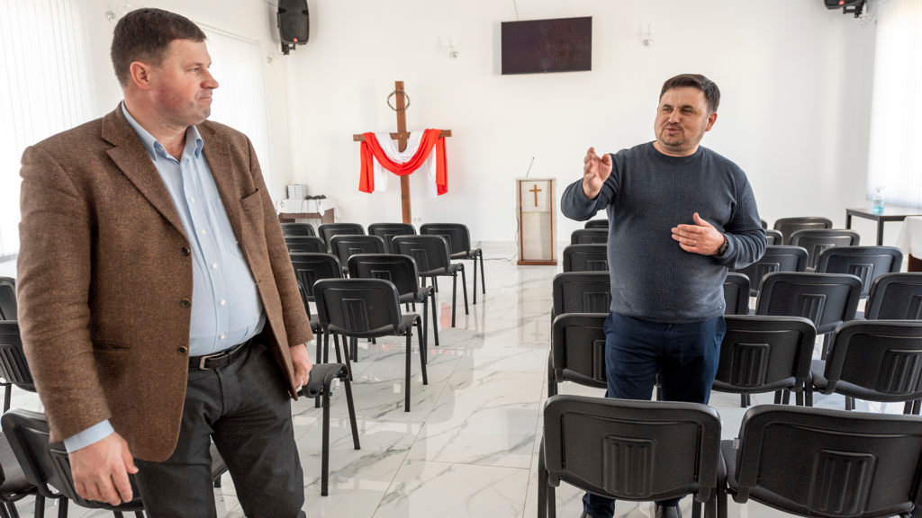 Pastor Ion Burlacu, right, shares with Ion Miron, the Baptist General Secretary of the Moldovan Baptist Union, how his church built this chapel in a day as a place of worship for refugees and church members and to create space in the original building for refugees to stay. (IMB Photo)
