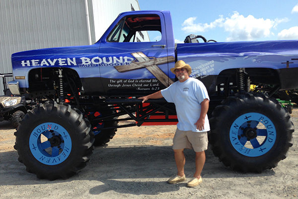 Terry Billings poses with the Heaven Bound Mud Bogger, a souped up pickup that draws crowds everywhere it goes. (Photo/The Baptist Paper)