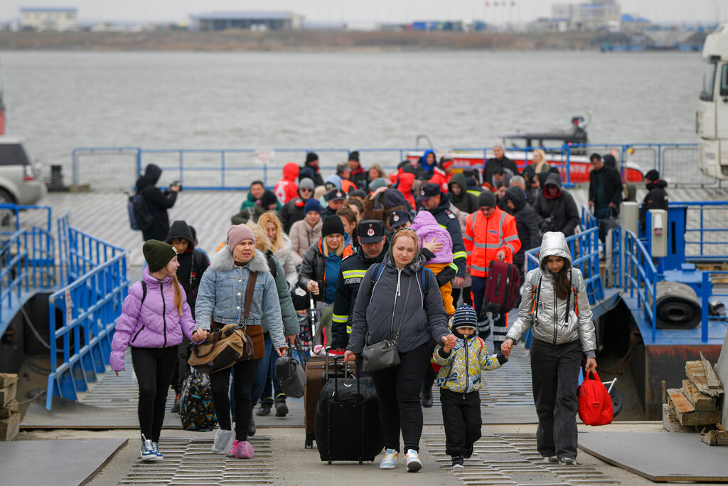 Refugees fleeing the war from neighboring Ukraine walk after crossing into Romania by ferry March 25, 2022. (AP Photo/Andreea Alexandru, File)
