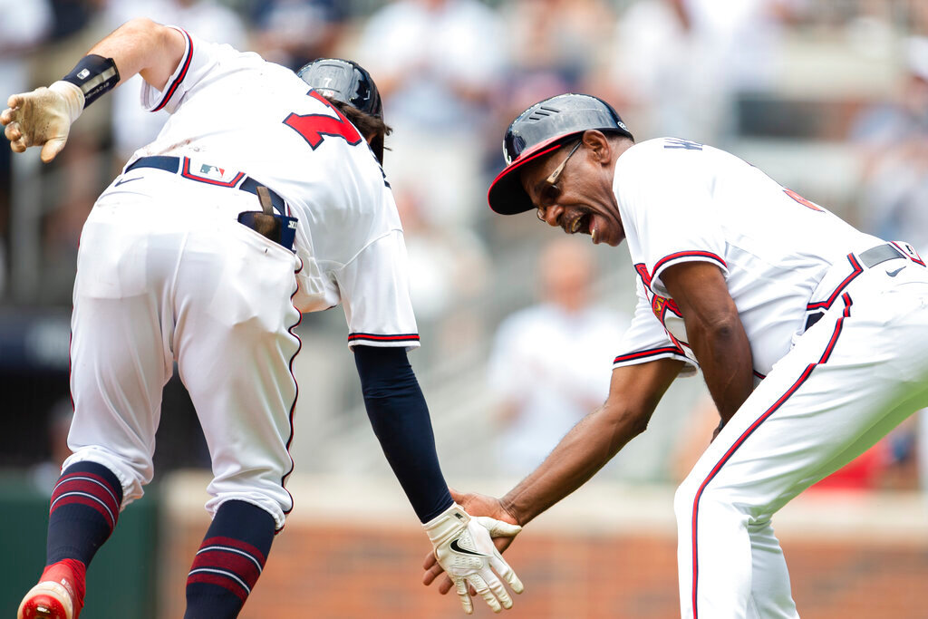 Atlanta Braves third base coach Ron Washington (37) slaps hands with Atlanta Braves Dansby Swanson (7) after Swanson hit a home run in the fourth inning against the San Diego Padres, Sunday, May 15, 2022, in Atlanta. (AP Photo/Hakim Wright Sr)