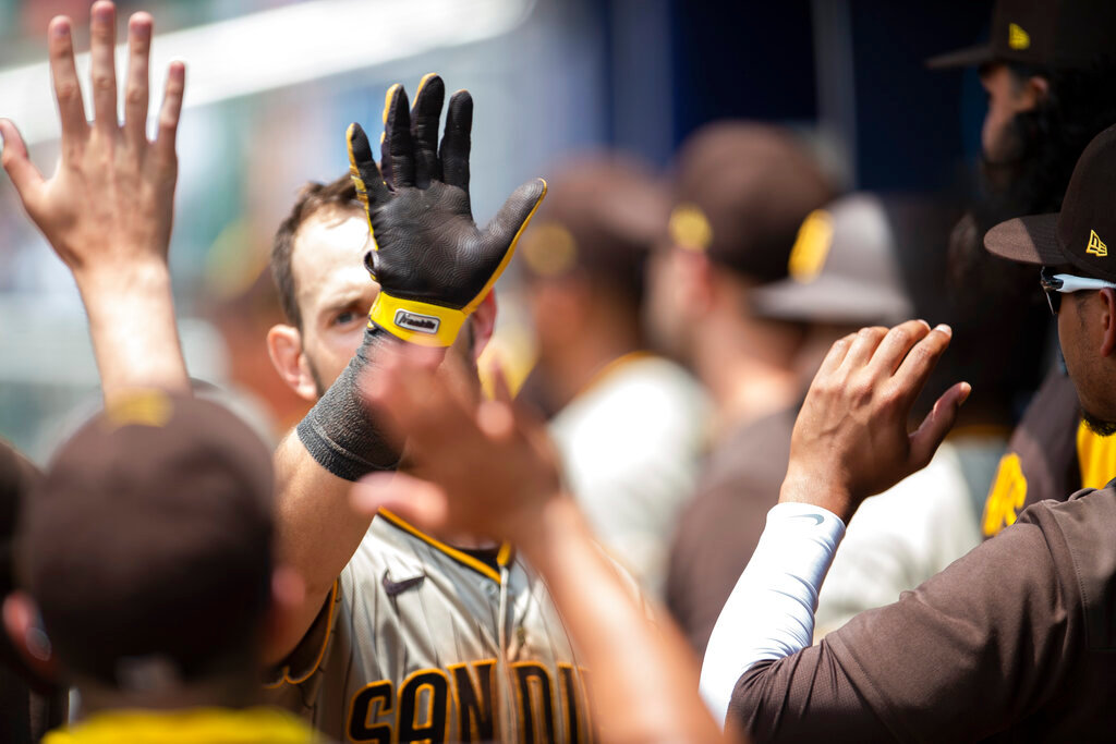 San Diego Padres' Wil Myers high-fives teammates after scoring during the seventh inning against the Atlanta Braves, Sunday, May 15, 2022, in Atlanta. (AP Photo/Hakim Wright Sr)