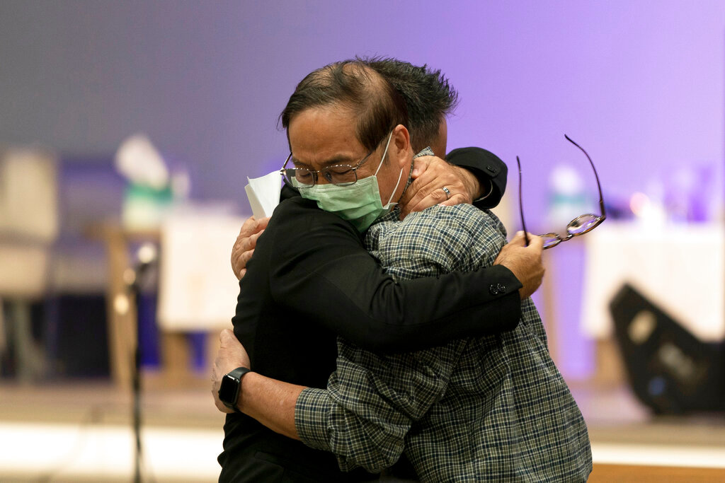 Jason Aguilar, left, a senior pastor at Arise Church, comforts Billy Chang, a 67-year-old Taiwanese pastor who survived Sunday’s shooting at Geneva Presbyterian Church, during a prayer vigil in Irvine, Calif., Monday, May 16, 2022. Authorities say a Chinese-born gunman was motivated by hatred against Taiwan when he chained shut the doors of the church and hid firebombs before opening fire on a gathering of mainly of elderly Taiwanese parishioners. (AP Photo/Jae C. Hong)
