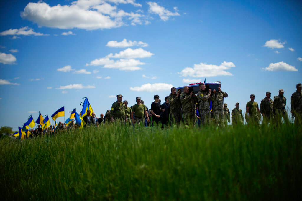 Ukrainian soldiers carry the coffin of Volodymyr Losev during his funeral in Zorya Truda, Odesa region, Ukraine, Monday, May 16, 2022. Losev, a Ukrainian volunteer soldier, was killed May 7 when the military vehicle he was driving ran over a mine in eastern Ukraine. (AP Photo/Francisco Seco)