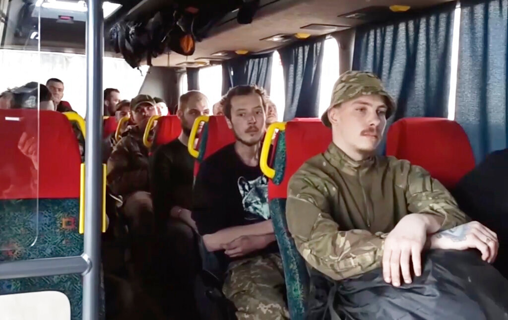 Ukrainian servicemen sit in a bus as they are evacuated from the besieged Azovstal steel plant in Mariupol, Ukraine, Tuesday, May 17, 2022. More than 260 fighters, some severely wounded, were pulled from a steel plant on Monday that is the last redoubt of Ukrainian fighters in the city and transported to two towns controlled by separatists, officials on both sides said. (Russian Defense Ministry Press Service via AP)