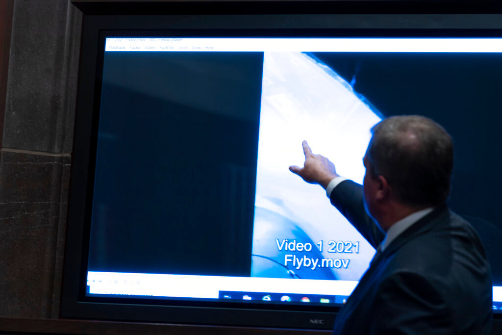 Deputy Director of Naval Intelligence Scott Bray points to a video display of an "unidentified aerial phenomena," or UAP,  during a House subcommittee hearing on Capitol Hill, Tuesday, May 17, 2022, in Washington. (AP Photo/Alex Brandon)