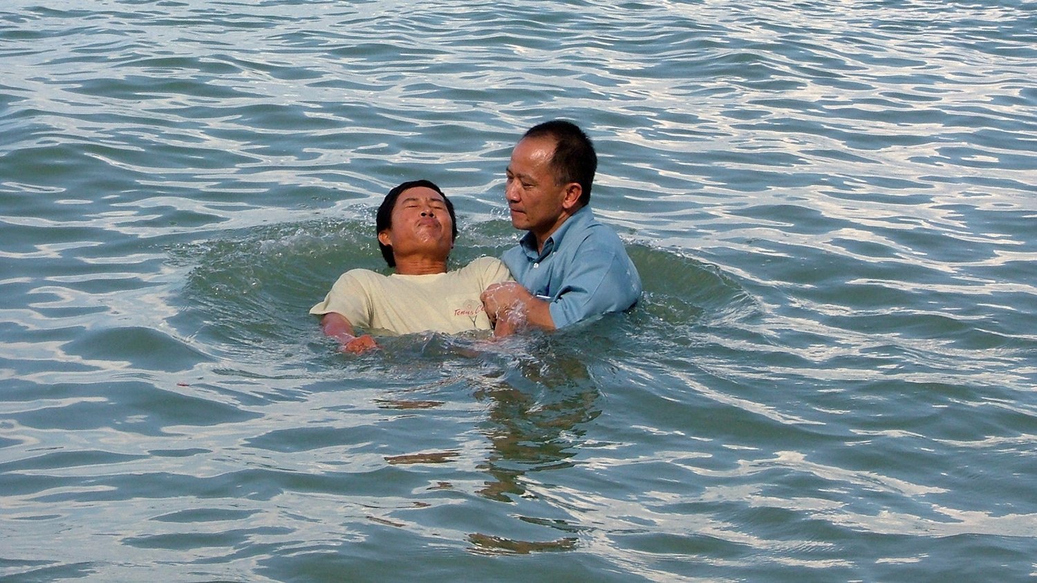 Henry Phan baptizes a new believer in Southeast Asia. Henry and his wife, Thu, shared Jesus’ redeeming love and discipled new believers in five different countries during their 20-plus year career with the IMB. (IMB Photo)