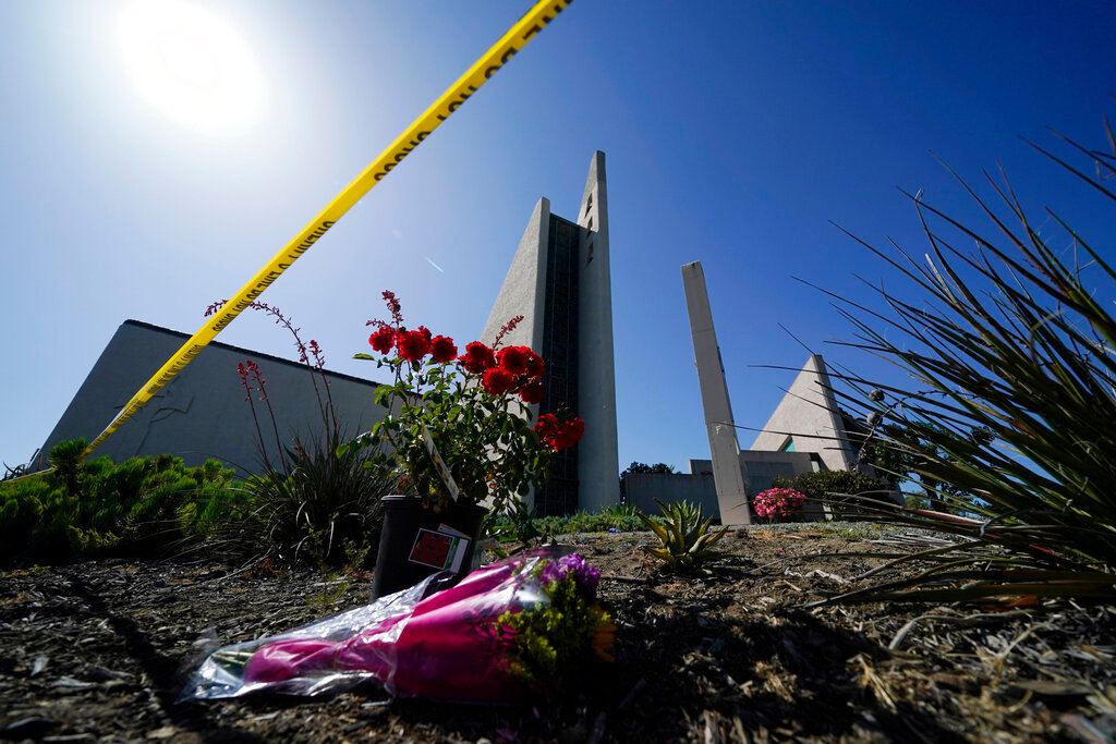 Flowers sit beneath crime scene tape at Geneva Presbyterian Church on May 17, 2022, in Laguna Woods, Calif. (AP Photo/Ashley Landis, File)