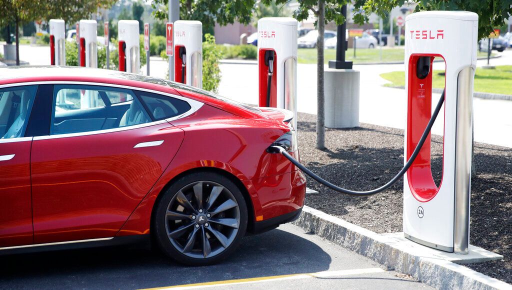 A Tesla Model S is plugged in at a vehicle charging station in Seabrook, N.H., Aug. 24, 2018. The driver of a Tesla operating on autopilot must stand trial for a crash that killed two people in a Los Angeles suburb, a judge ruled Thursday, May 19, 2022.  (AP Photo/Charles Krupa, File)