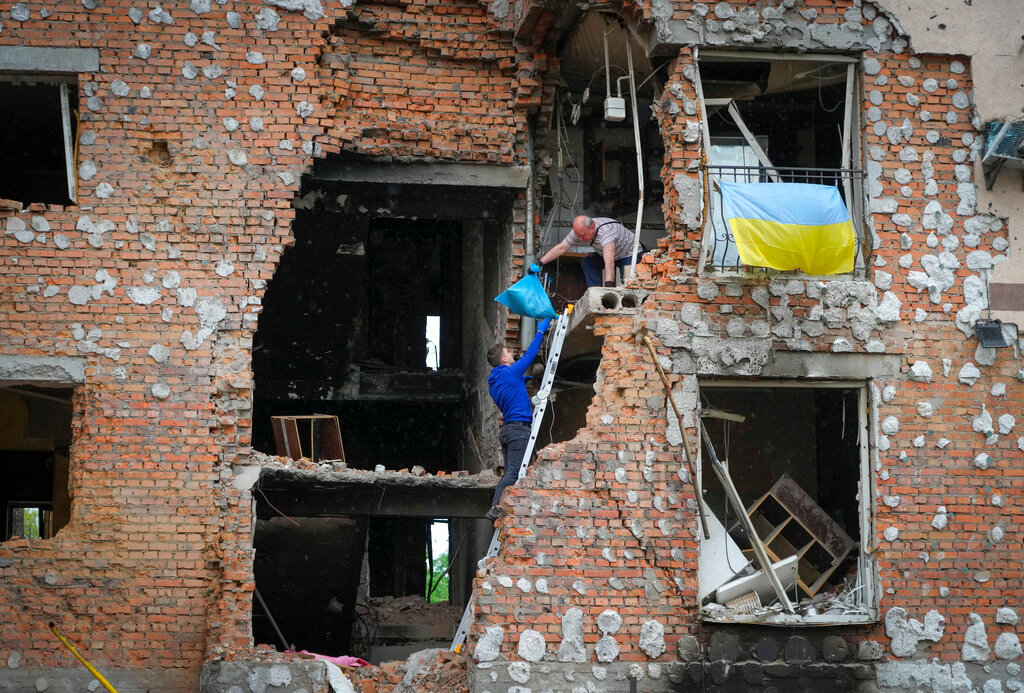 Residents take out their belongings from their house ruined by the Russian shelling in Irpin close to Kyiv, Ukraine, Saturday, May 21, 2022. (AP Photo/Efrem Lukatsky)