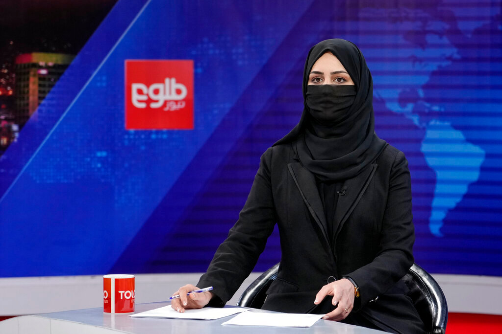 Khatereh Ahmadi, a TV anchor. wears a face covering as she reads the news on TOLO NEWS, in Kabul, Afghanistan, Sunday, May 22, 2022. (AP Photo/Ebrahim Noroozi)