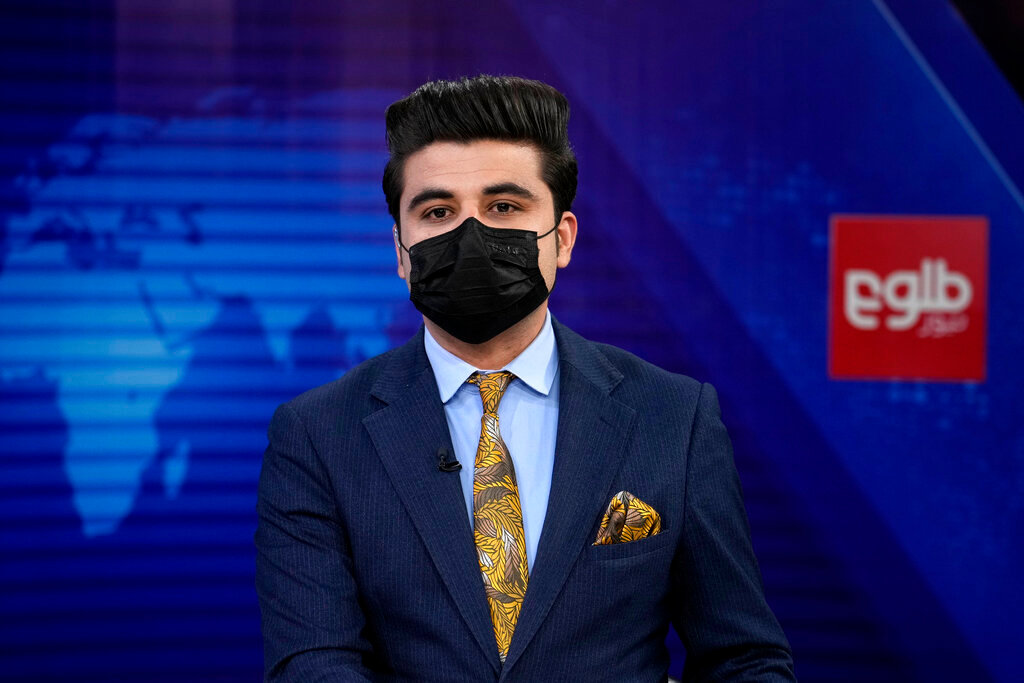 TV anchor Nesar Nabil wears a face mask to protest the Taliban's new order that female presenters cover their faces, as he reads the news on TOLOnews, in Kabul, Afghanistan, Sunday, May 22, 2022. (AP Photo/Ebrahim Noroozi)