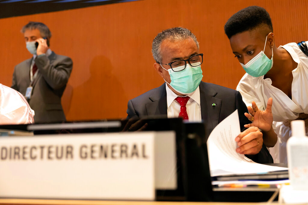 Tedros Adhanom Ghebreyesus, left, director general of the World Health Organization, talks with a WHO's staff, prior the first day of the 75th World Health Assembly at the European headquarters of the United Nations in Geneva, Switzerland, Sunday, May 22, 2022. (Salvatore Di Nolfi/Keystone via AP)
