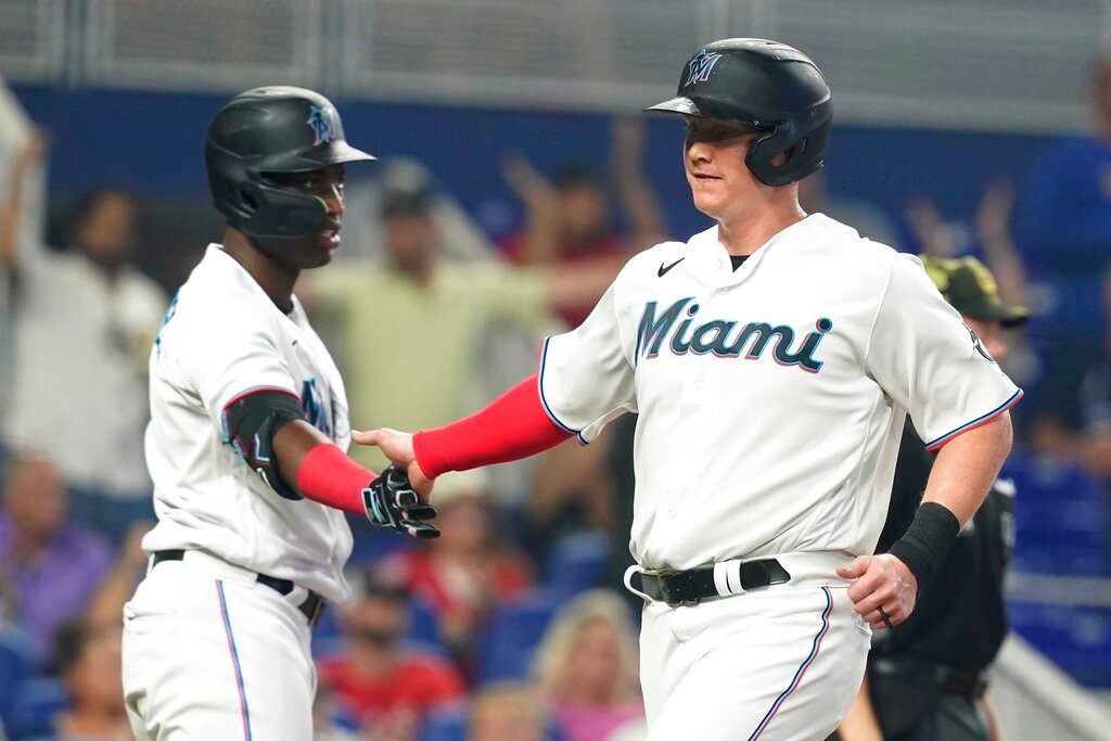 Miami Marlins' Garrett Cooper, right, is congratulated by Jesus Sanchez after Cooper scored on a hit by Brian Anderson in the sixth inning against the Atlanta Braves, Sunday, May 22, 2022, in Miami. (AP Photo/Marta Lavandier)