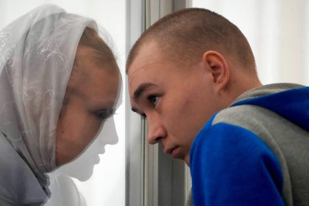 Russian Sgt. Vadim Shishimarin listens to his translator during a court hearing in Kyiv, Ukraine, Monday, May 23, 2022. The court sentenced the 21-year-old soldier to life in prison on Monday for killing a Ukrainian civilian, in the first war crimes trial held since Russia's invasion. (AP Photo/Natacha Pisarenko)