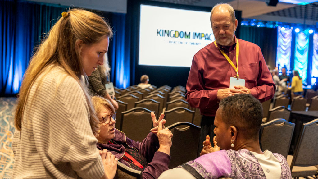 IMB staffer Jessica Rush, left, visits with missionary emeriti to the deaf Yvette Aarons, right, Danny Bice, and Vesta Sauter at the Celebration of Emeriti event in Orlando, Fla. (IMB Photo)