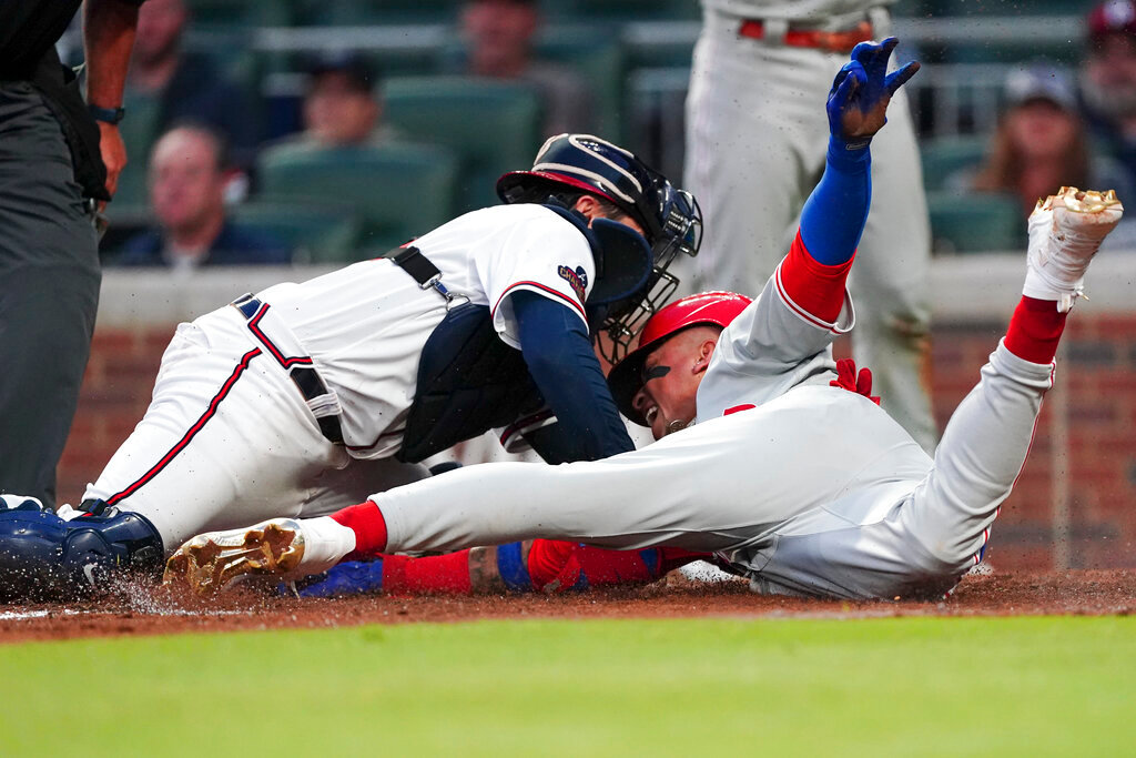 Philadelphia Phillies' Johan Camargo, right, beats the tag from Atlanta Braves catcher Travis d'Arnaud to score on a two-run double by Roman Quinn in the third inning Monday, May 23, 2022, in Atlanta. (AP Photo/John Bazemore)