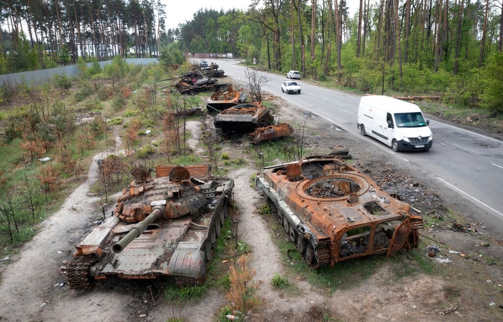 Cars pass Russian tanks destroyed in a recent battle against Ukrainians in the village of Dmytrivka, close to Kyiv, Ukraine, May 23, 2022.  (AP Photo/Efrem Lukatsky, File)