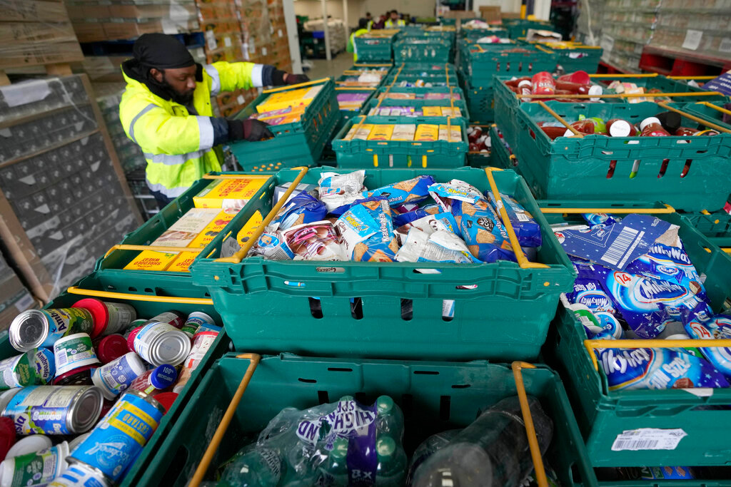 A volunteer from the charity 'The Felix Project' collects food at their storage hub in London, Wednesday, May 4, 2022. (AP Photo/Frank Augstein)