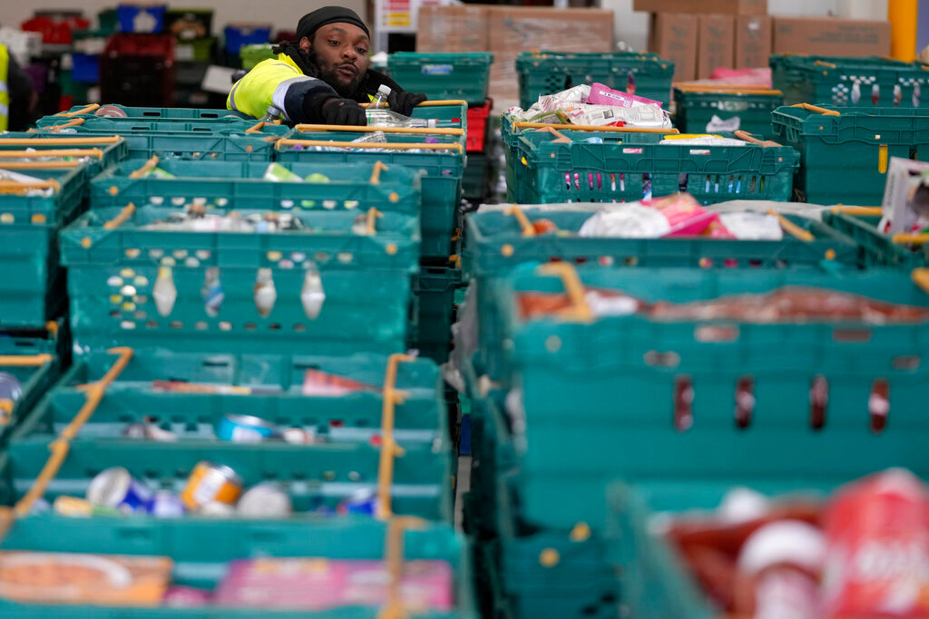 A volunteer from the charity 'The Felix Project' collects food at their storage hub in London, Wednesday, May 4, 2022. (AP Photo/Frank Augstein)